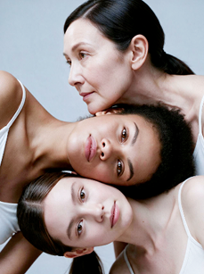 Three women of different ages, heads together